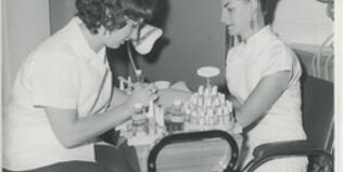 Person in beehive hairdo gets a manicure