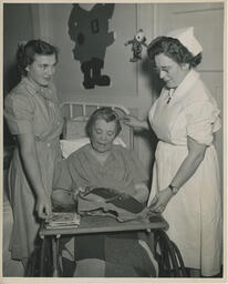 Elderly patient doing needlework while nursing students watch