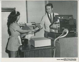 Server handing cheque to cashier, ca. 1972