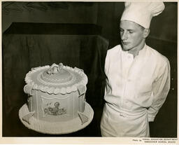 Baking student looks at a cake, ca. 1951
