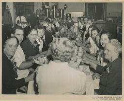 People seated at a long banquet table, ca. 1953