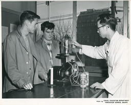 Students using batteries with an electrical device, ca. 1962