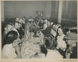 Group of people seated at a long table, ca. 1953