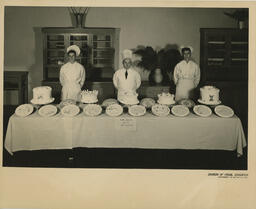 People standing behind cake display