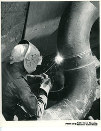 Student welding a pipe, ca. 1972