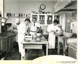 Instructor supervising students in a kitchen, ca. 1959