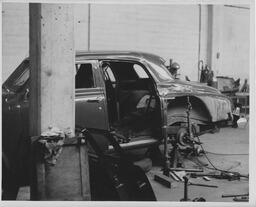 Car with door off in body shop