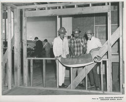 Students in hardhats looking at drafting plans, ca. 1968