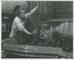 Student lowering an engine into a car