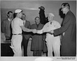 Plastering student and instructor shaking hands, ca. 1955