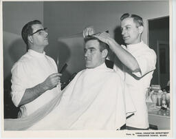 Barbering student giving customer a haircut, ca. 1968