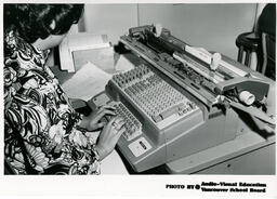 Student typing at adding machine, ca. 1972