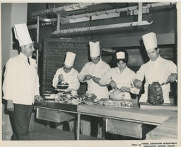 Four students preparing different food items, ca. 1968