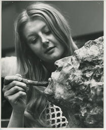 Close up of student painting the face of sculpture