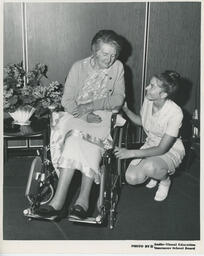 Student nurse and elderly person in wheelchair, ca. 1972