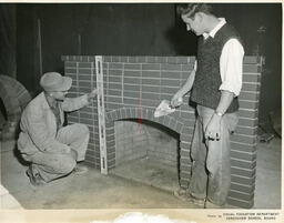 Two plastering student working on a brick fireplace, ca. 1955
