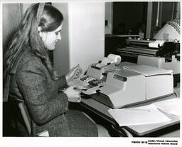Student uses a machine to make a card, ca. 1970