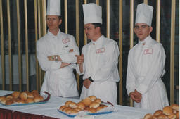 Three chefs stand behind a table