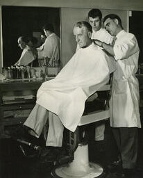 Barbering student cutting customer's hair, ca. 1959