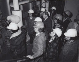 Students in hardhats on a tour of industrial building