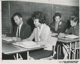Students sitting at desks beside a chalkboard