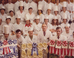 Class of student chefs and instructors pose with award ribbons, ca. 1980