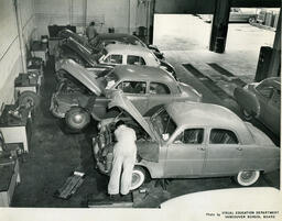 Cars with their hoods open in an auto shop classroom, ca. 1957