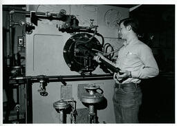 Student holding a rod at a machine