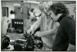 Two students testing an electronic device