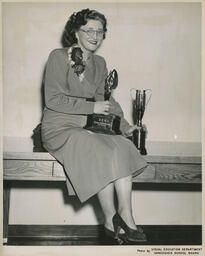 Beauty Culture student Melita Lasko with trophies, ca. 1951