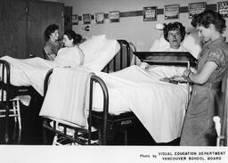 Two nursing students tending to patients, ca. 1959