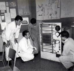 Four students looking at refrigeration machine