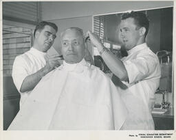 Customer getting a haircut from barbering student and instructor, ca. 1963