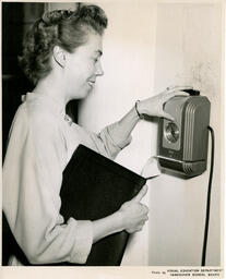 Student using a punch clock, ca. 1952