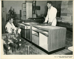 Two students working on drawers for a kitchen set, ca. 1960