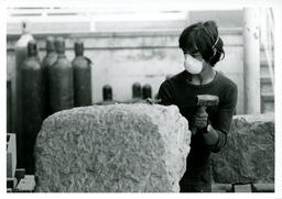 Student chiseling a square chunk of rock.