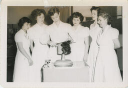 Beauty Culture students watching a haircut on wooden pedestal