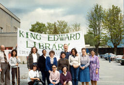 Library employees posing in front of a Banner before the "Last Great Trek" ca. 1982
