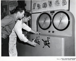 Navigation student turning a dial on a navigation tool, ca. 1962