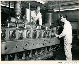 Two students work on a large machine