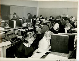 Students in a classroom typing at desks, ca. 1959