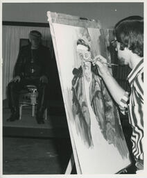 Student painting portrait of person in chair