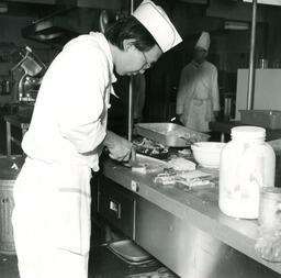 Student chef cutting crusts