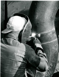 Student welding a pipe, ca. 1972