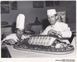 Two students decorating fish on a platter