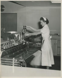 Server pours a beverage, ca. 1949