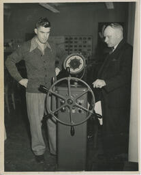 Navigation student at a ship's wheel, ca. 1949