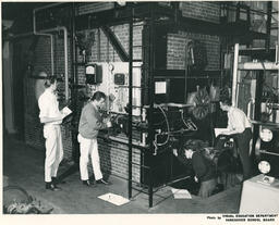Power Engineering students looking at a wall of machines, ca.1966