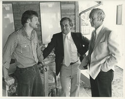 Three people standing and talking about the housing project, ca. 1980