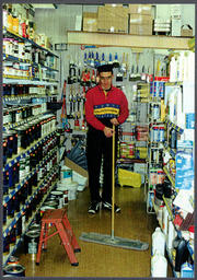 Student sweeps floor of a hardware store
